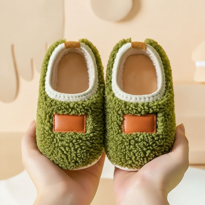 Green textured slip-on slippers with tan patches and cream-colored trim