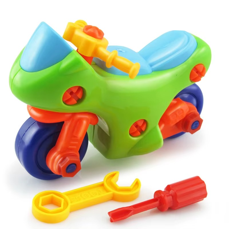 Green toy motorcycle with a blue seat, yellow wrench, and red screwdriver