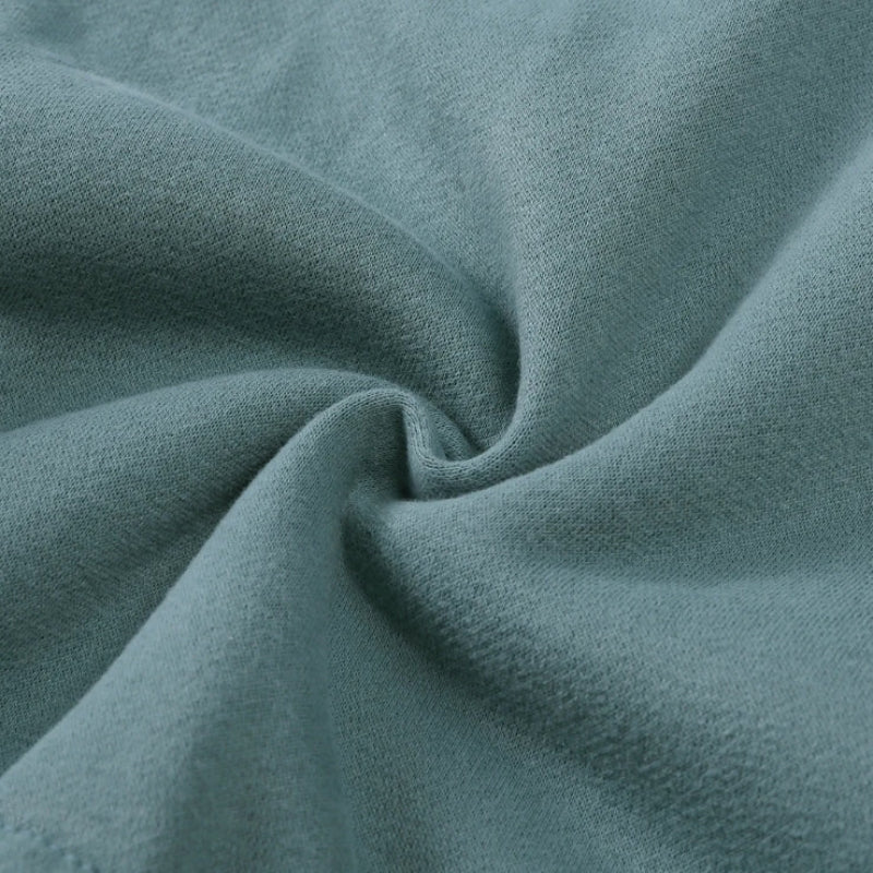 Green tracksuit fabric gathered to show its surface texture