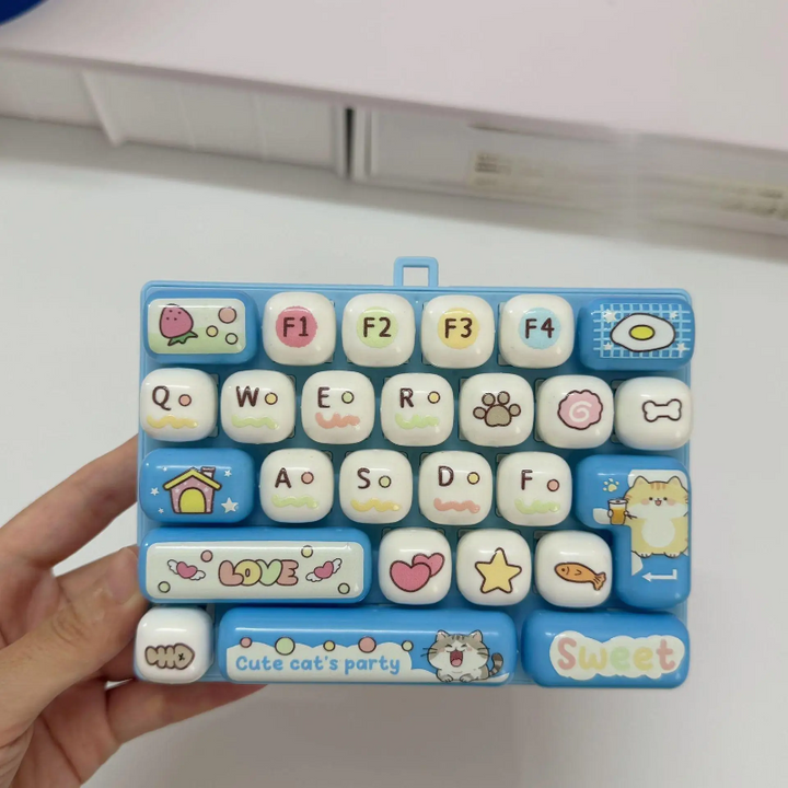 Hand holding a light blue fidget keyboard with rounded letter and picture keys
