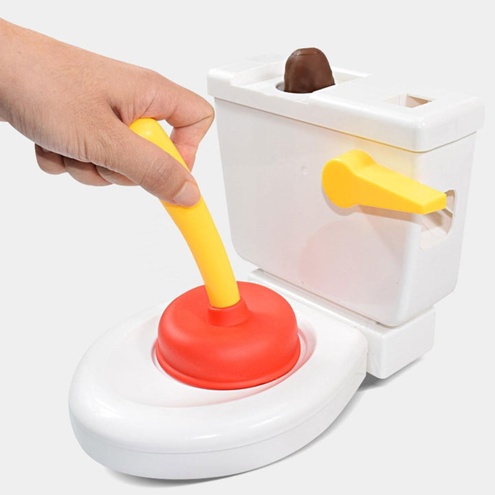 A hand pushing the yellow-handled red plunger on the white toilet game