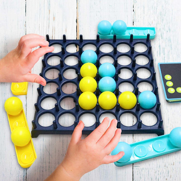 Hands around the grid board with yellow and blue balls, matching trays, and a challenge card