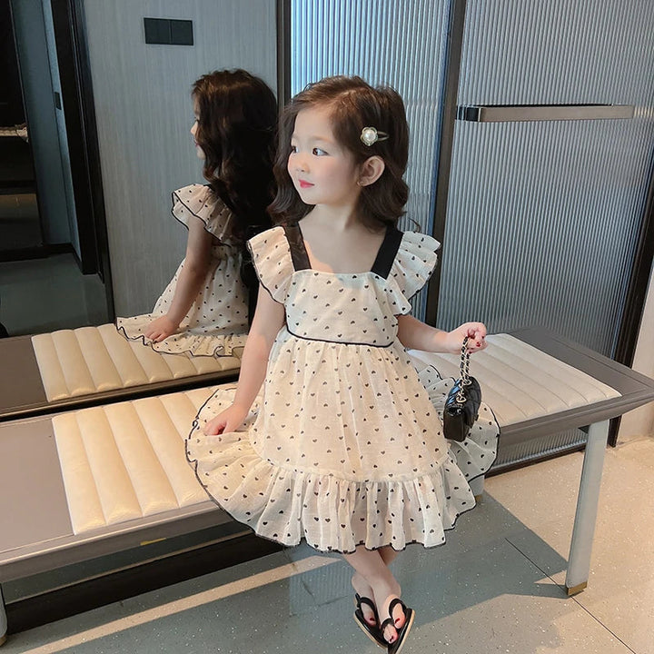 Heart-patterned dress showing black waist piping and a wide ruffled hem