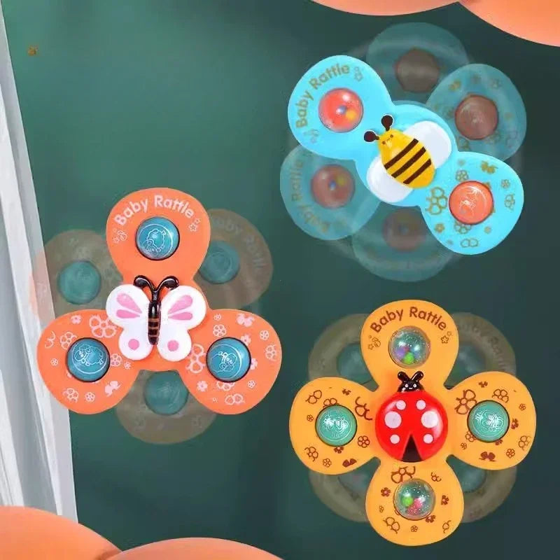 Bee, butterfly, and ladybug bath spinners shown rotating on a dark vertical surface.