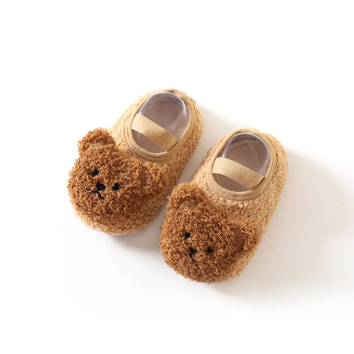 Pair of khaki baby slippers with brown bear faces and elastic bands