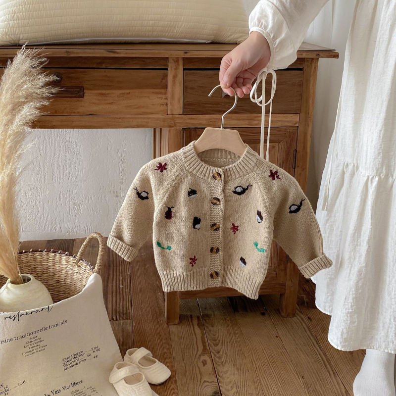 Khaki knit cardigan with a round neckline, ribbed edges and button front on a hanger