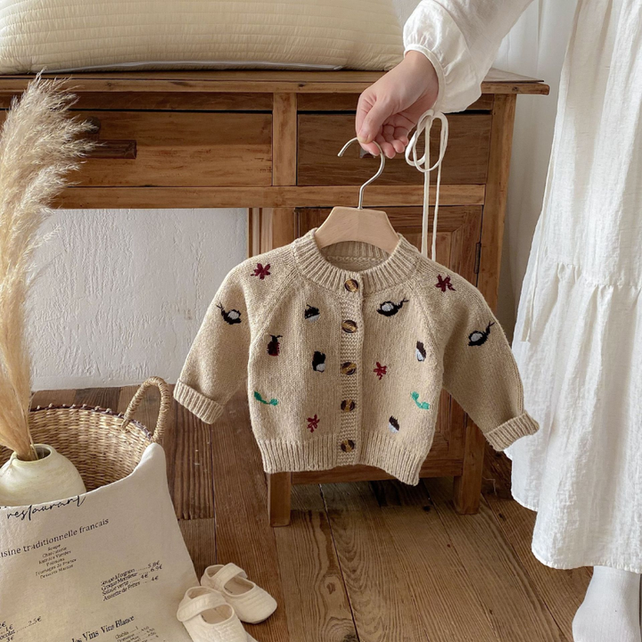 Khaki knit cardigan with a round neckline, ribbed edges and button front on a hanger