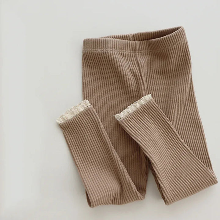 Khaki ribbed leggings with the legs folded up to show the lace cuffs.