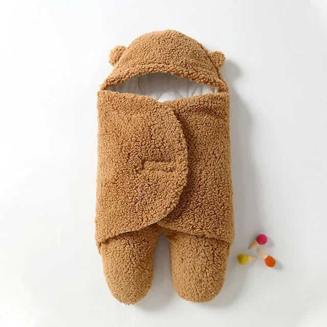 Khaki baby wrap blanket with a sherpa exterior, overlapping wings, and covered feet.