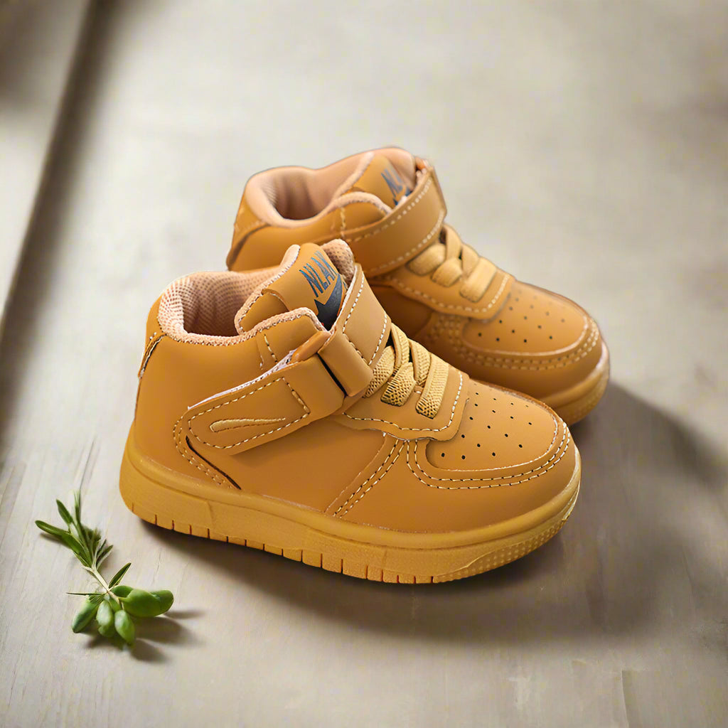 Pair of khaki high-top sneakers with matching soles on a tabletop