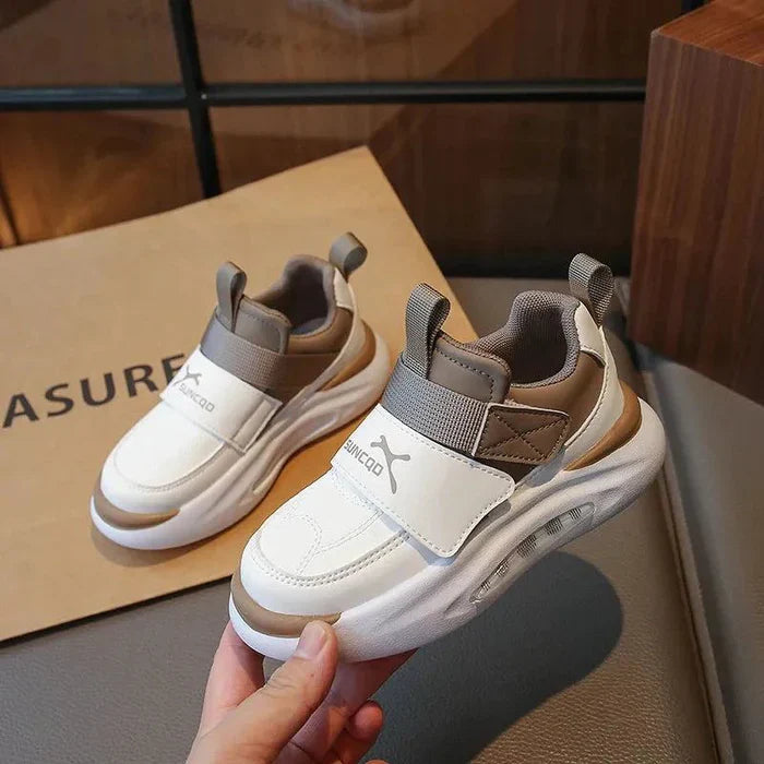 Khaki and white kids' sneakers with wide straps, pull tabs, and thick soles