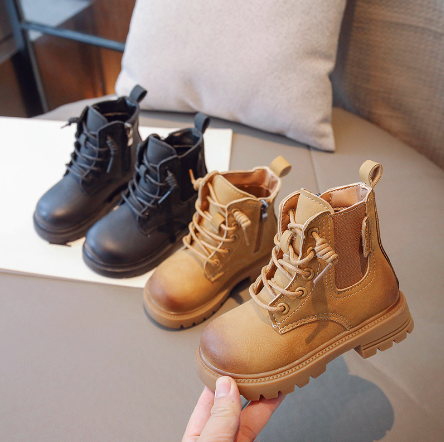 Black and khaki kids' lace-up ankle boots, with a khaki boot held in front