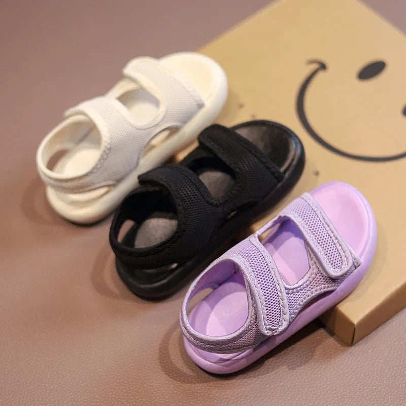 Beige, black, and purple kids' sandals with mesh uppers and two adjustable straps