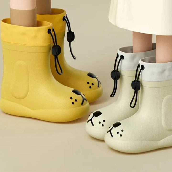 Children wearing yellow and white dog-face rain boots with black drawcord cuffs