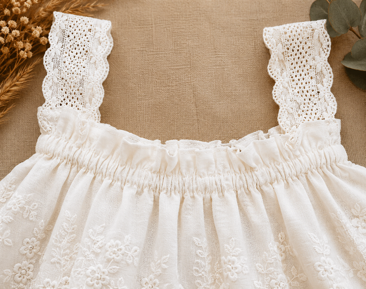 Close-up of wide lace straps and the gathered neckline on the white top