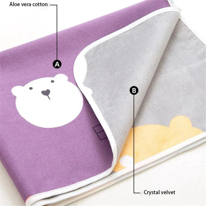 Folded changing mat showing a purple bear print, gray reverse, and white bound edge.