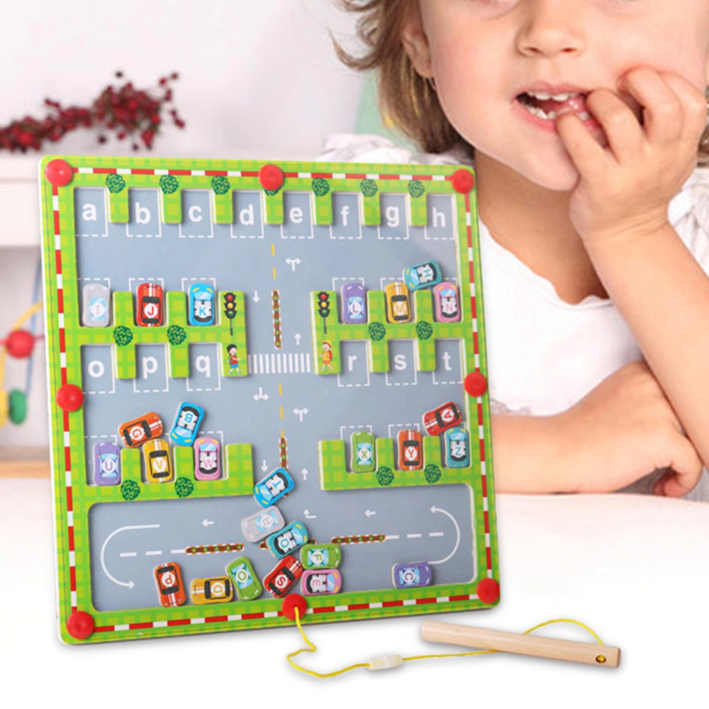 Wooden alphabet maze beside a child, with colorful lettered cars and a magnetic pen