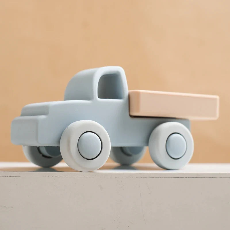 Light blue silicone toy truck with a beige bed and pale wheels