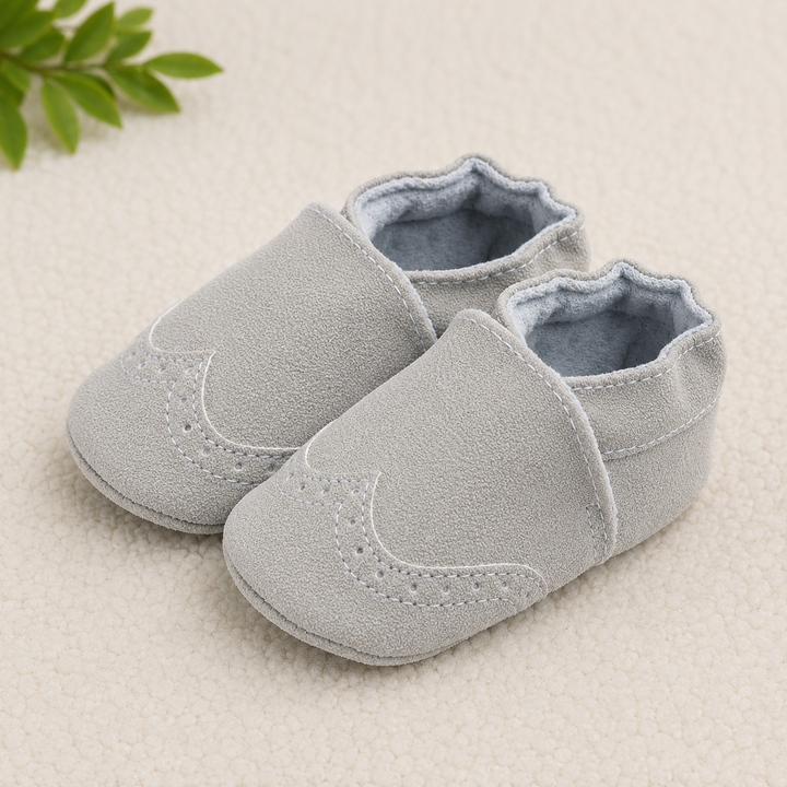 Light gray baby shoes with curved toe panels and gathered ankle openings