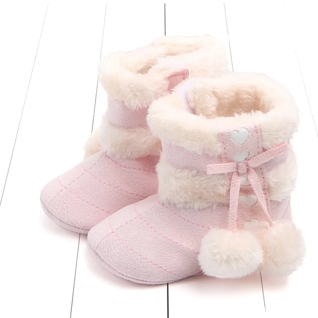 Light pink baby snow boots with fluffy cream cuffs and heart-trimmed fronts