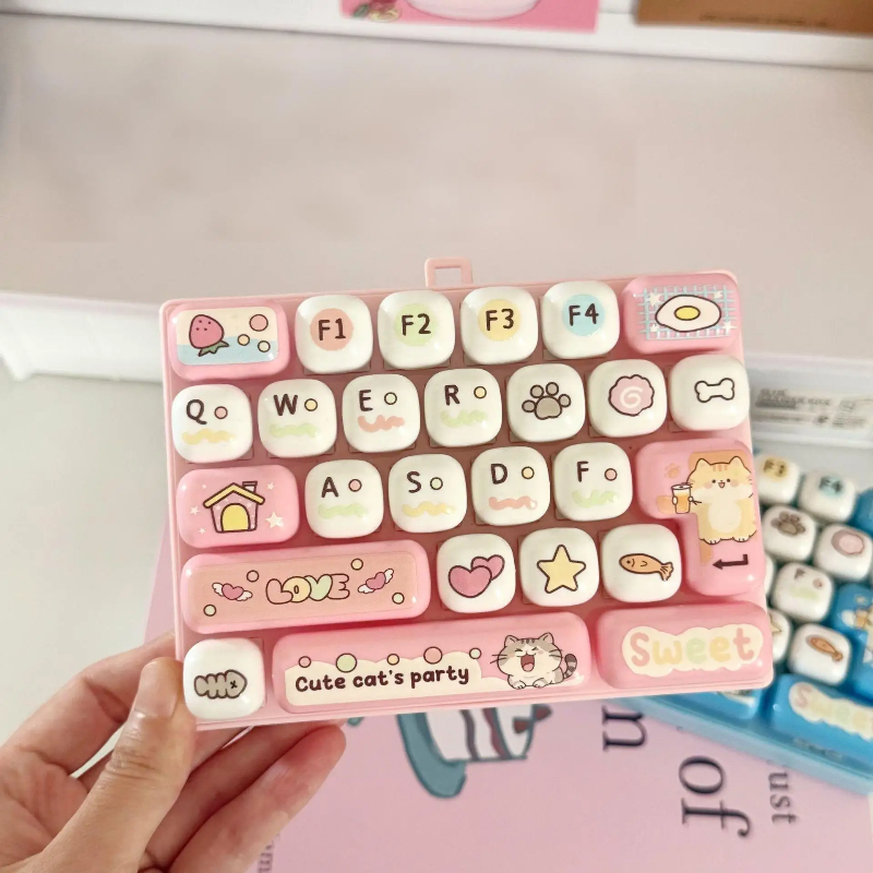Light pink fidget keyboard held above a pink book