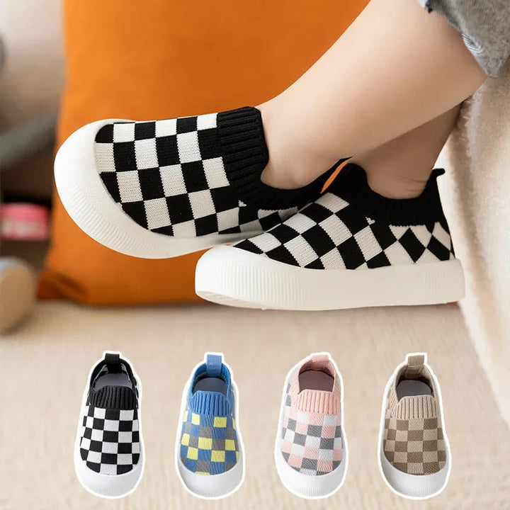 Black-and-white checkered slip-on shoes worn on a child&