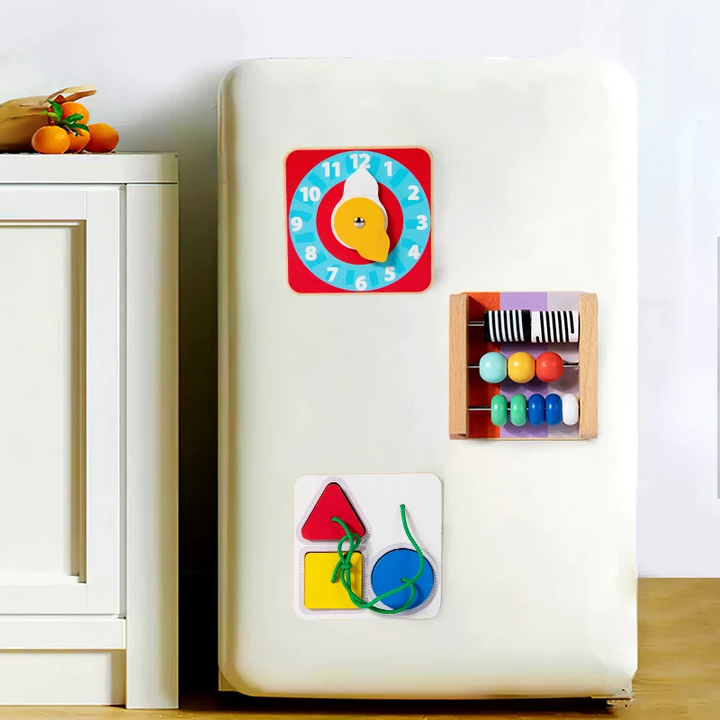 Clock, counting-bead, and shape-matching busy boards attached to a refrigerator door.