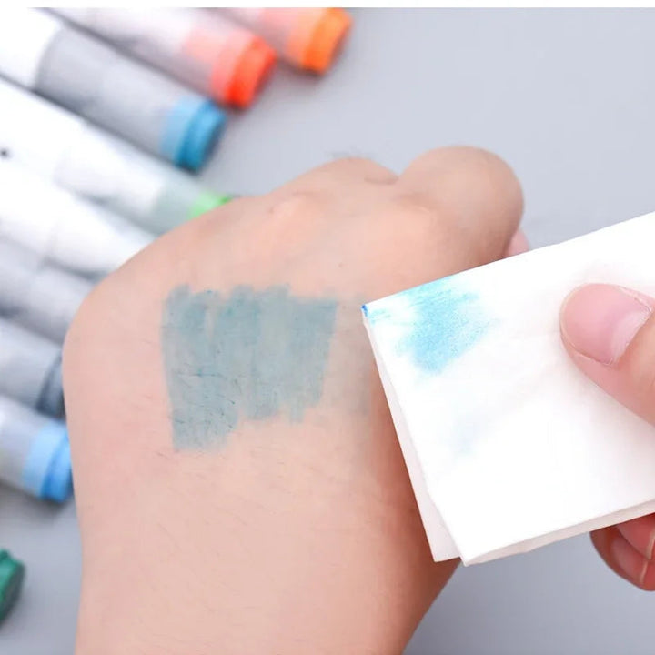Blue ink on a hand being wiped with a white pad