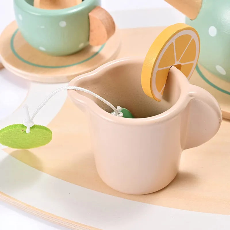 Wooden milk jug holding a pretend lemon slice and tea bag beside a cup and teapot