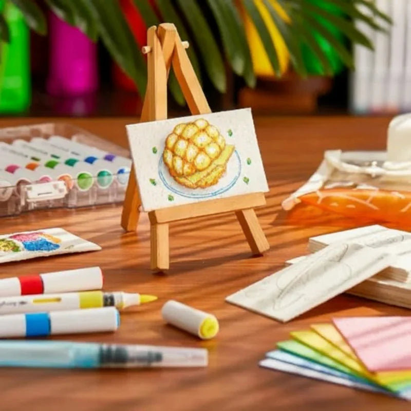Mini easel displaying textured bun artwork beside markers and art supplies