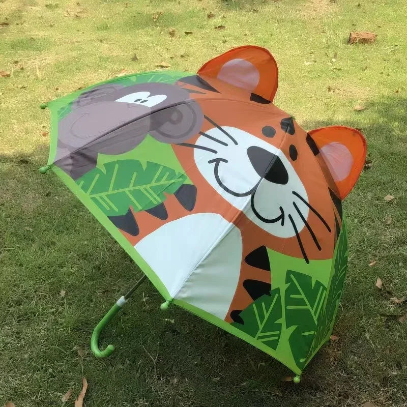 Monkey and tiger umbrella with leafy patterns and a green handle, displayed on grass