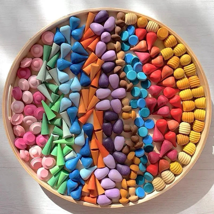 Multicolored wooden play pieces arranged in rows inside a round tray