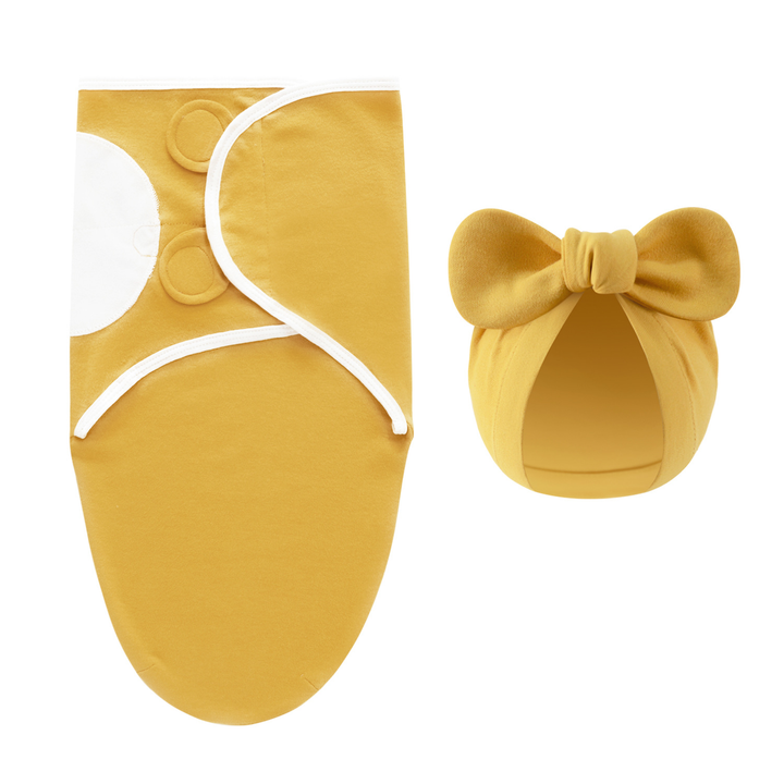 Mustard yellow swaddle blanket with white edging and a matching bow hat
