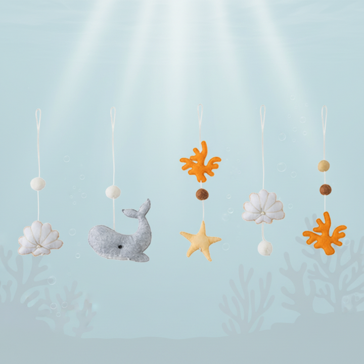 Ocean hanging toy set with a whale, shells, a starfish, coral shapes, and beads.