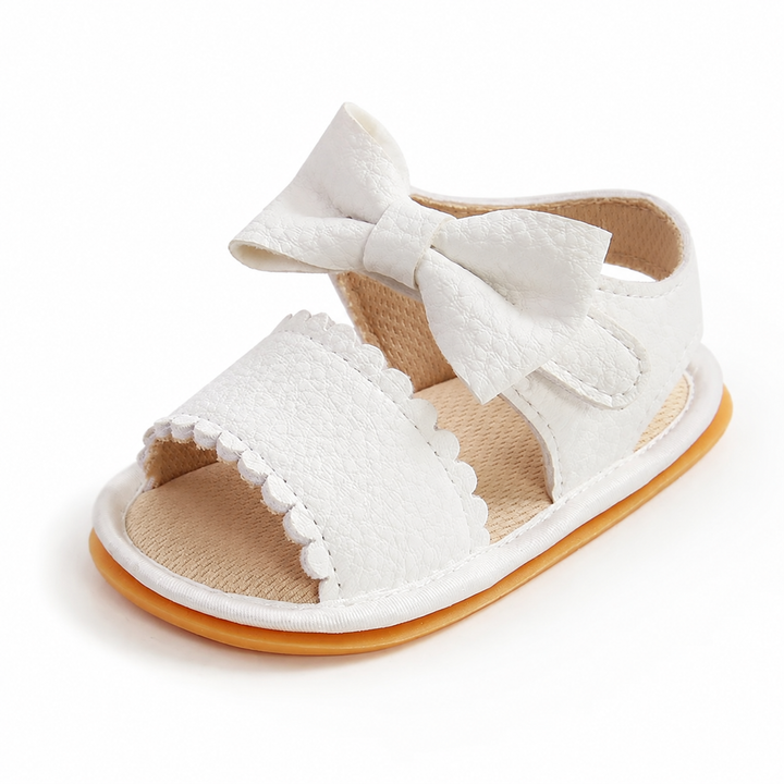 Off-white baby sandal with a bow, scalloped front strap, and open toe