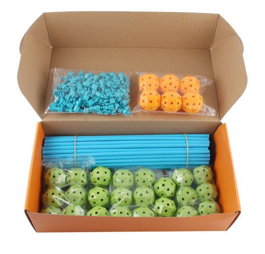 Open box holding blue poles, green and orange connector balls, and small blue connecting pieces