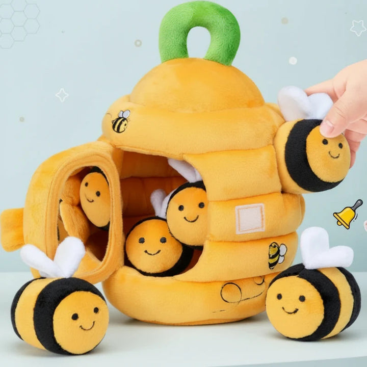 Yellow plush beehive with an open front door and small bee toys inside and around it