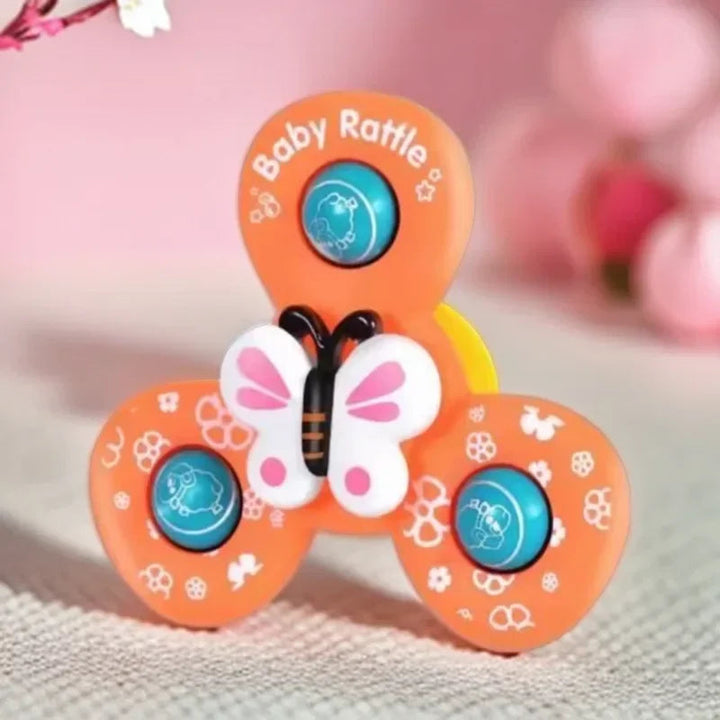 Close-up of the orange three-arm bath spinner with a pink-and-white butterfly center.