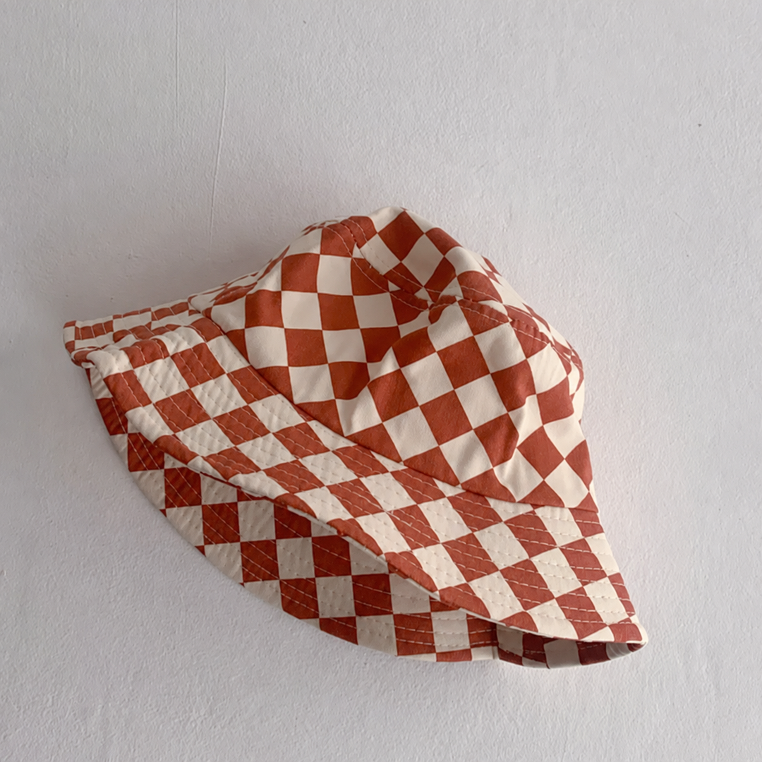 Orange-and-cream checkered bucket hat with a rounded crown and stitched brim