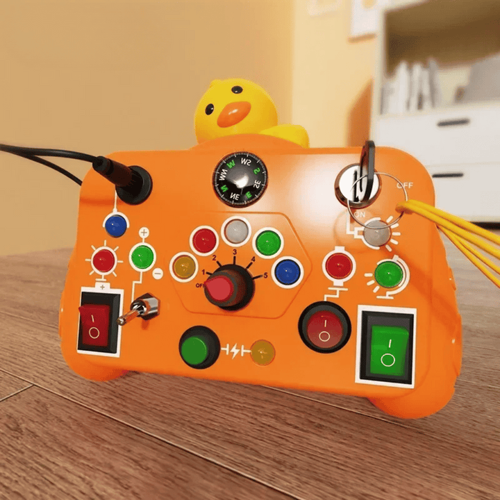 Orange activity board with a duck topper, rotary dial, key, buttons, and rocker switches