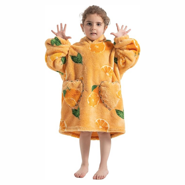Child wearing an orange fruit-print hooded blanket with two front pockets