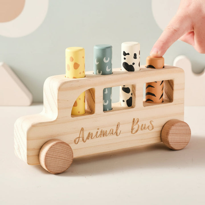 Hand pressing the orange peg on a wooden bus with three other patterned pegs