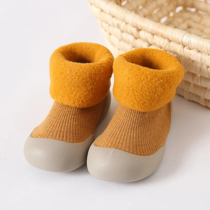 Orange ribbed baby socks with plush folded cuffs and light-colored soles