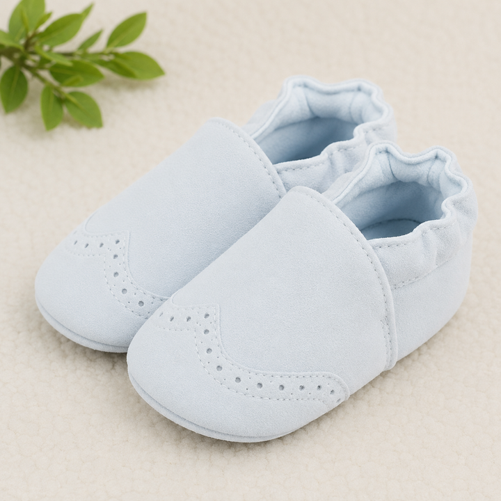 Pale blue baby shoes with brogue-style perforations and elastic ankle openings