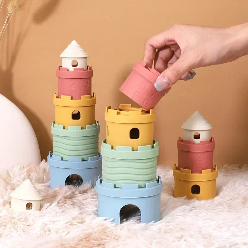 Hand placing a pink cup on one of several pastel castle towers