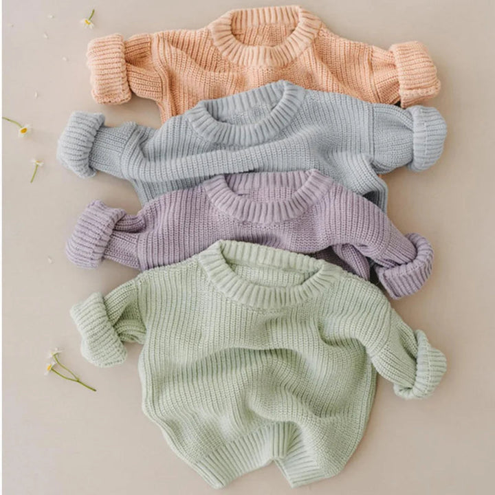Peach, light blue, lavender, and light green knit sweaters arranged together.