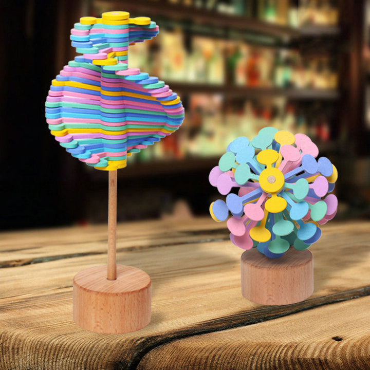 Two pastel wooden rotating lollipop toys standing on a wooden table