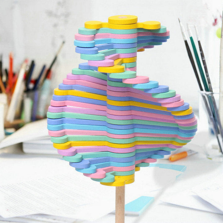 Close-up of pastel wooden layers arranged in a twisting shape on a rotating lollipop toy