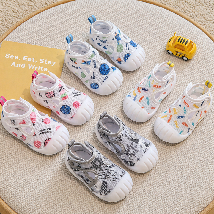 Patterned baby strap shoes in blue, pink, gray, and multicolor designs with white toe caps.