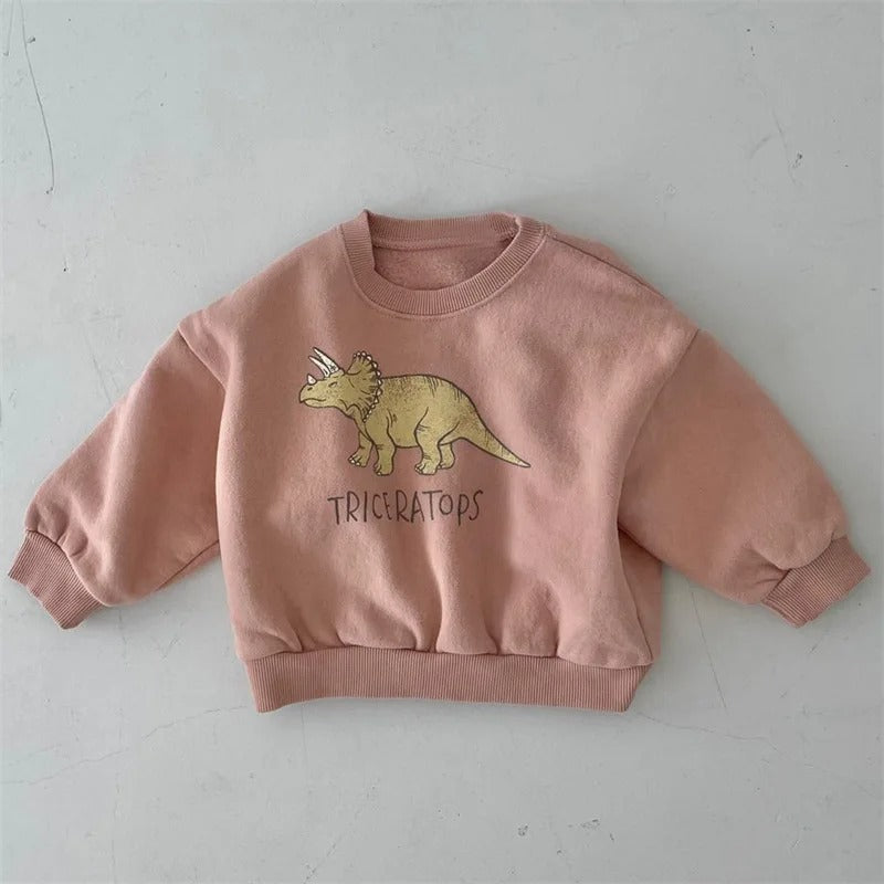 Peach-pink crewneck sweatshirt with a yellow triceratops graphic and ribbed cuffs